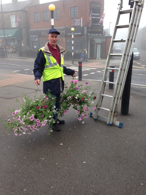 Putting hanging baskets up in the precinct